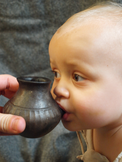 A modern-day infant sipping from a reconstructed feeding vessel of the type analyzed in the new study.